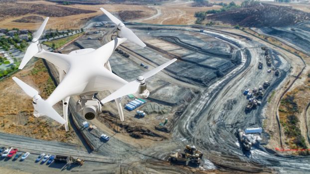 Unmanned Aircraft System (UAV) Quadcopter Drone In The Air Over Construction Site.