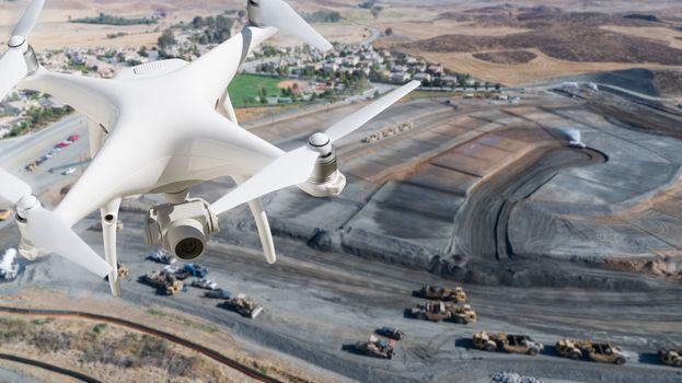 Unmanned Aircraft System (UAV) Quadcopter Drone In The Air Over Construction Site.