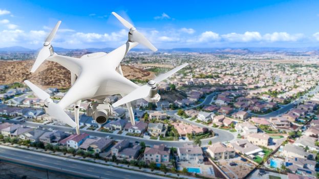 Unmanned Aircraft System (UAV) Quadcopter Drone In The Air Over Residential Neighborhood.