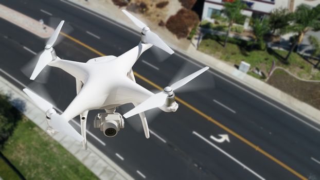 Unmanned Aircraft System (UAV) Quadcopter Drone In The Air Over Roadway.