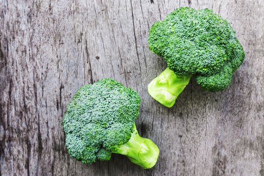 Closeup top view fresh broccoli on wooden background, raw food for cooking