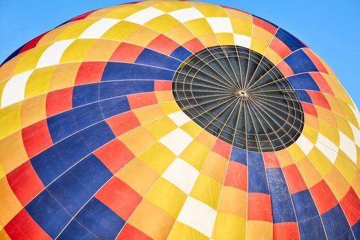 Closeup of a colorful hot-air balloon during the inflation