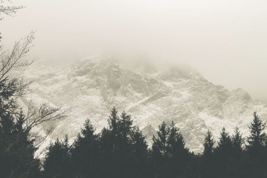 View of a mountain range with snow and clouds