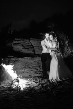 young couple the bride and groom warm around the fire at night