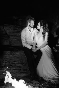 young couple the bride and groom warm around the fire at night