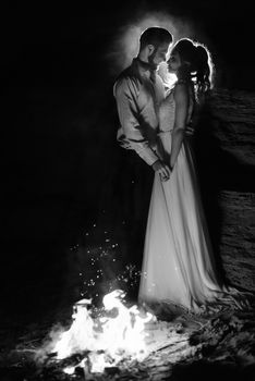 young couple the bride and groom warm around the fire at night