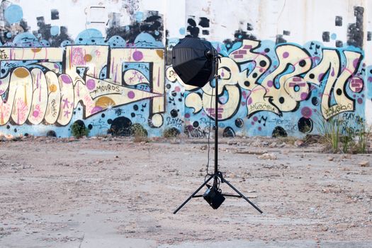 Tripod with flash head on a beauty dish in nature.