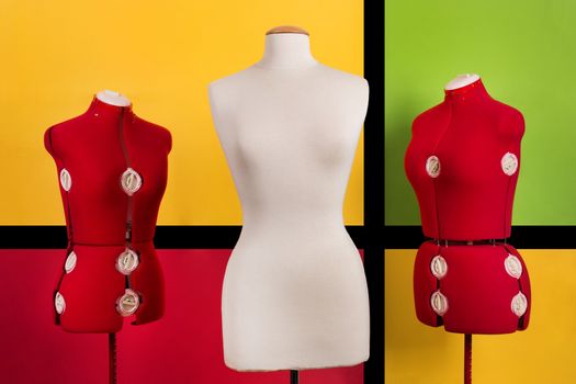 Close view of three dressmaker dummies over a colorful background.