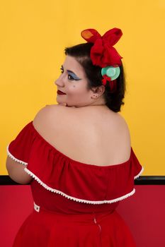 View of pinup vintage girl next to a colorful red and yellow background.