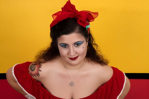 View of pinup vintage girl next to a colorful red and yellow background.