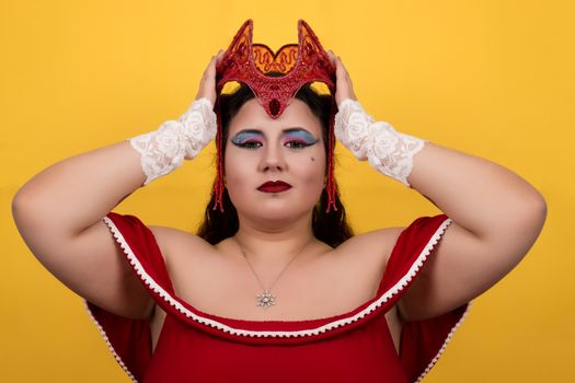 View of pinup vintage girl holding a red fantasy crown over a yellow background.