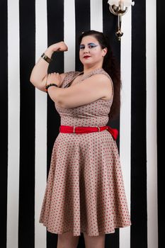 Pinup girl posing on a black and white stripes backdrop.