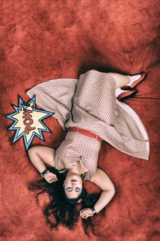 Pinup girl posing on red blacket bed in her bedroom.