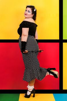 View of pinup vintage girl next to a colorful pop art backdrop.