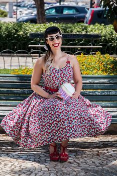 Pinup girl  with dress relaxing in the beautiful urban park.