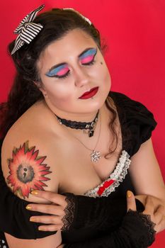 View of pinup vintage girl next to a colorfulred backdrop.