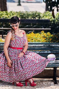 Pinup girl  with dress relaxing in the beautiful urban park.