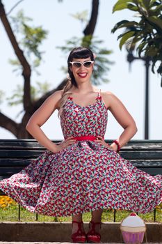 Pinup girl  with dress relaxing in the beautiful urban park.