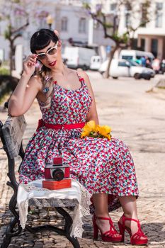 Pinup girl  with dress relaxing in the beautiful urban park.