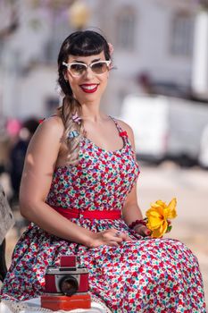 Pinup girl  with dress relaxing in the beautiful urban park.