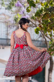 Pinup girl  with dress relaxing in the beautiful urban park.