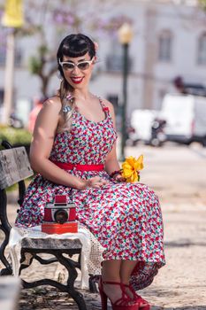 Pinup girl  with dress relaxing in the beautiful urban park.