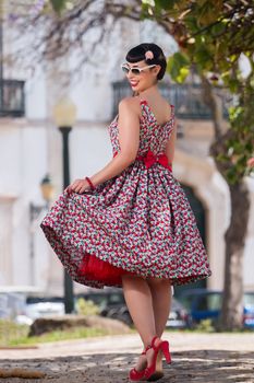 Pinup girl  with dress relaxing in the beautiful urban park.