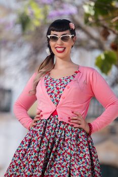 Pinup girl  with dress relaxing in the beautiful urban park.