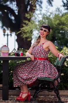 Pinup girl  with dress relaxing in the beautiful urban park.