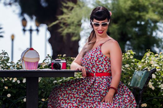 Pinup girl  with dress relaxing in the beautiful urban park.