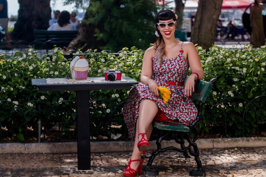 Pinup girl  with dress relaxing in the beautiful urban park.