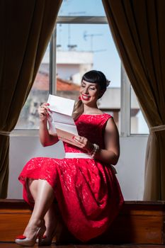 Pinup girl with red dress reading a romantic letter.