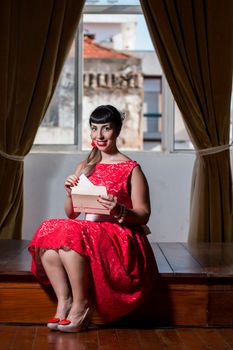 Pinup girl with red dress reading a romantic letter.