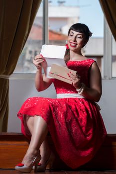 Pinup girl with red dress reading a romantic letter.