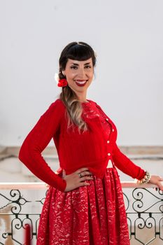 Pinup girl with red dress next to a classic window.