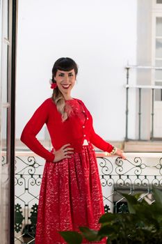 Pinup girl with red dress next to a classic window.