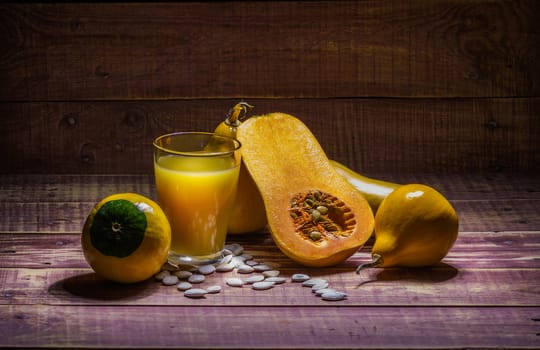 still life with pumpkin and pumpkin juice on a wooden table