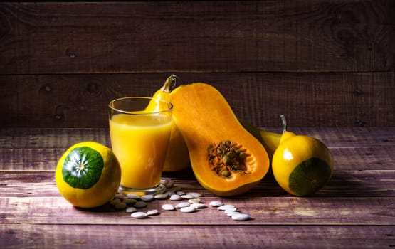 still life with pumpkin and pumpkin juice on a wooden table