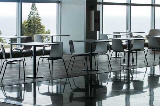 View of several white waiting room chairs and tables.