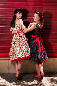 Women posing with a vintage style retro floral clothing.