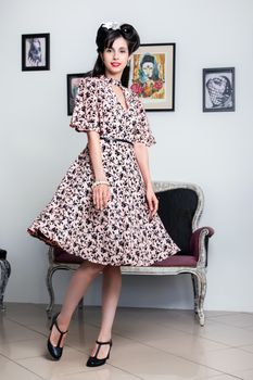 Woman posing with a vintage style retro floral clothing.