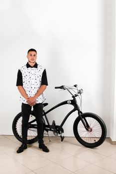 Teenager posing with a vintage style retro clothing and a bike.