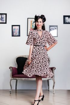 Woman posing with a vintage style retro floral clothing.