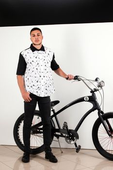 Teenager posing with a vintage style retro clothing and a bike.