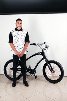 Teenager posing with a vintage style retro clothing and a bike.