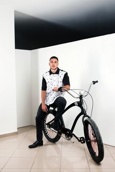 Teenager posing with a vintage style retro clothing and a bike.