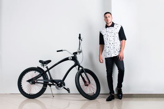 Teenager posing with a vintage style retro clothing and a bike.