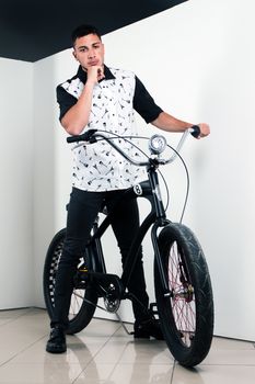 Teenager posing with a vintage style retro clothing and a bike.