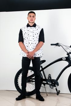 Teenager posing with a vintage style retro clothing and a bike.