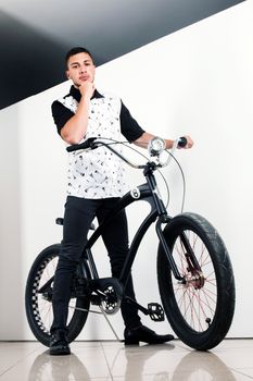 Teenager posing with a vintage style retro clothing and a bike.